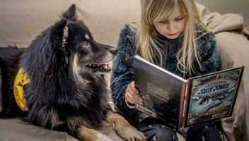 Flicka läser för bokhunden